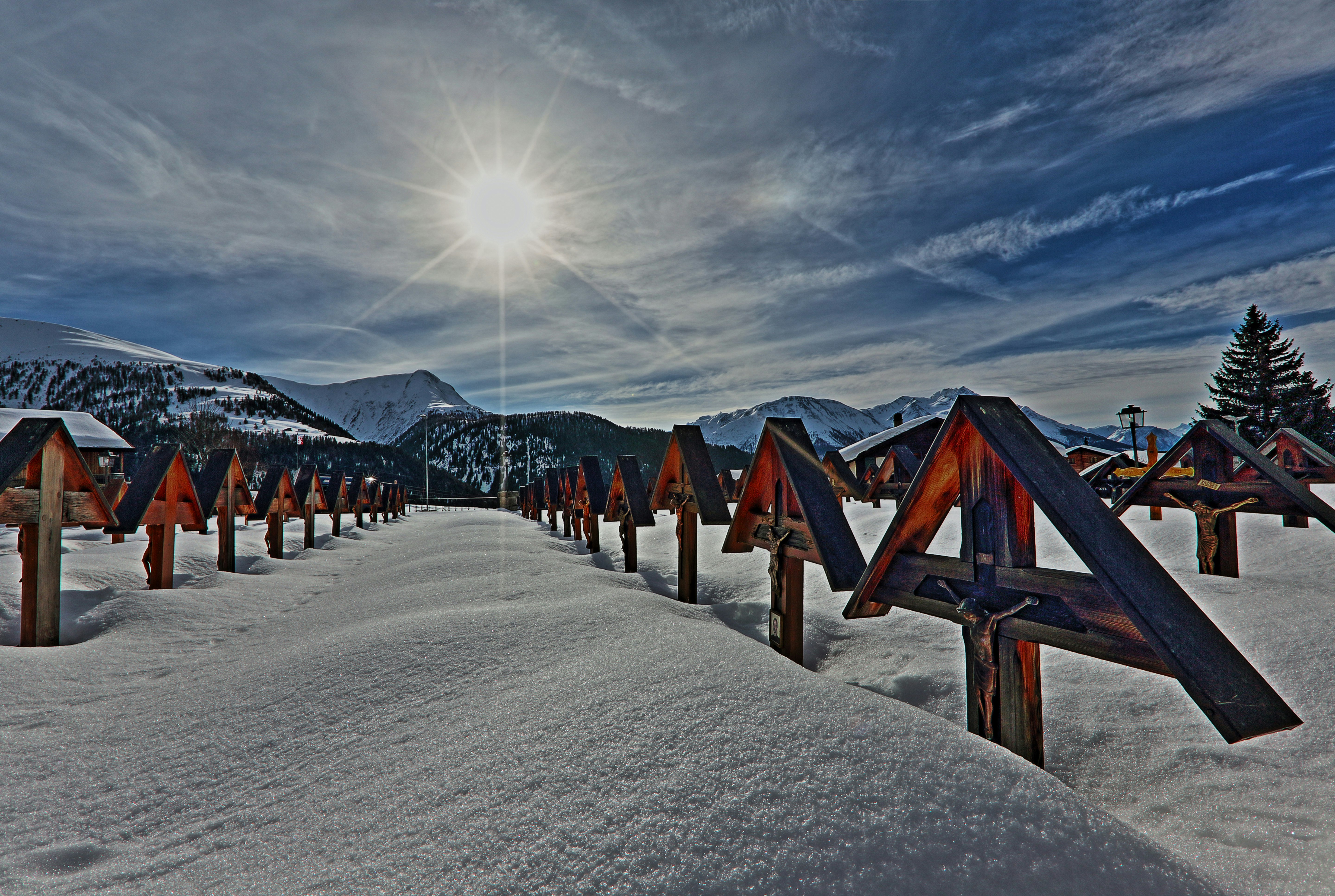 brown wooden houses on snow covered ground under gray cloudy sky during daytime